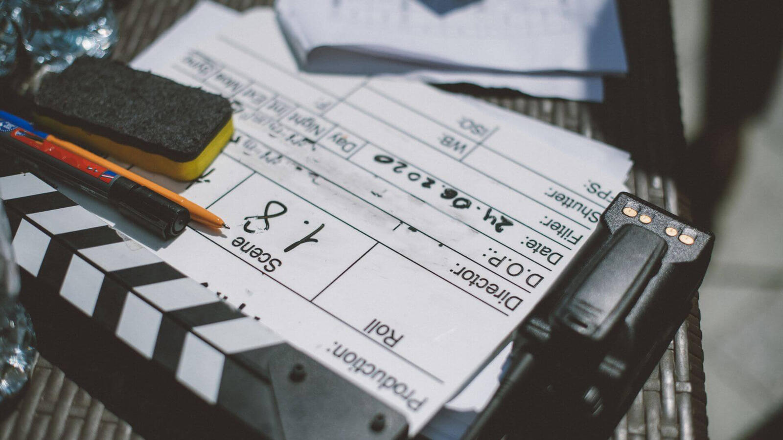 Production Check & Equipment Setup Close-up of a production clapperboard alongside professional film camera and technical equipment staged on set.