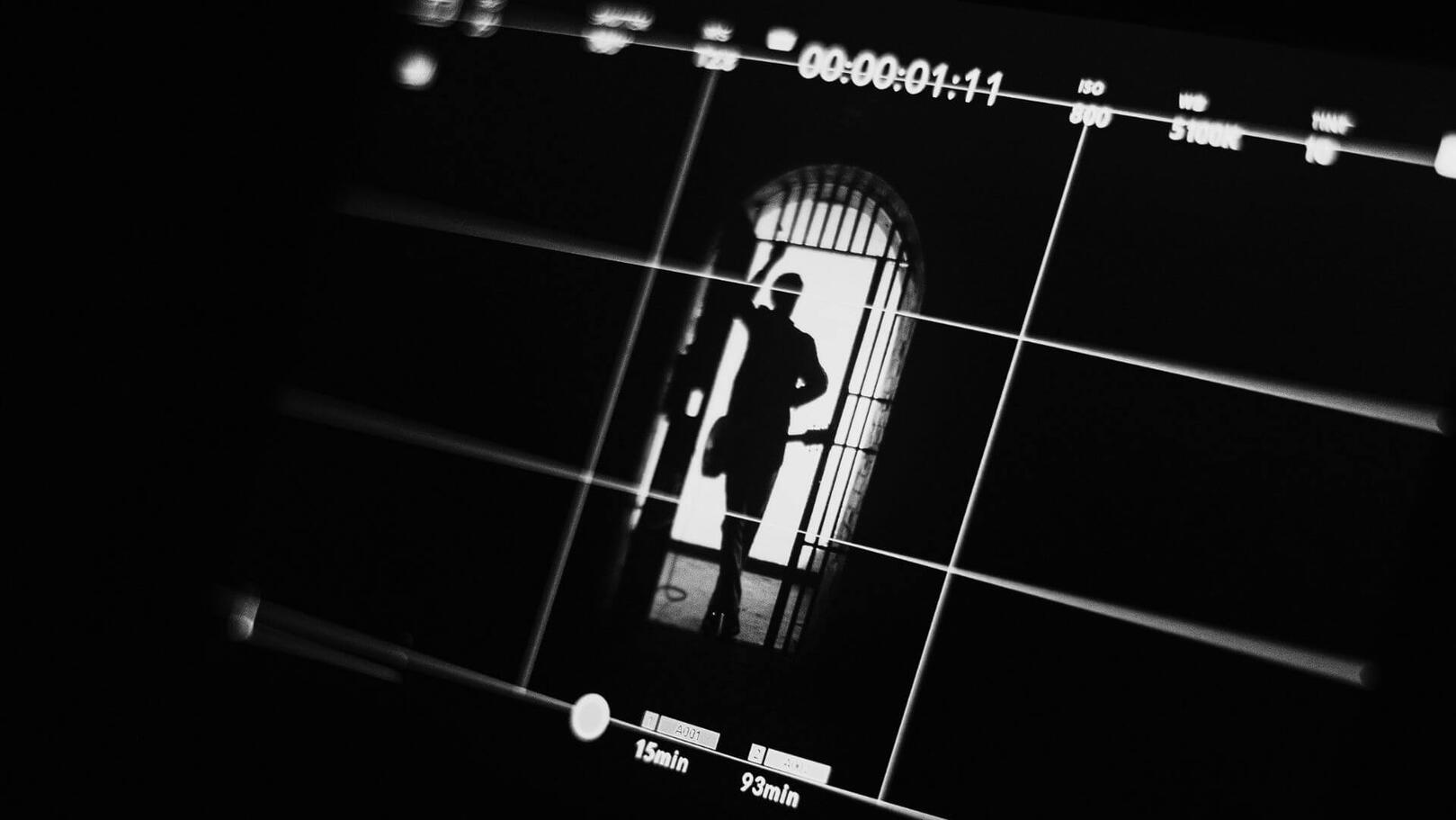 Cinematic Framing & Shot Vision — Director's Monitor | Jessica Evelyn Rodrigues de Lima On-set director's monitor displaying a scene frame with a composition grid overlay and character silhouette.